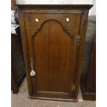 A 26" late Georgian stained oak wall hanging corner cabinet with canted sides and three scalloped