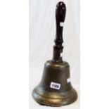 An 8" diameter brass hand bell with turned wood handle