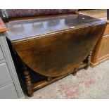 A 3' 6" polished oak gateleg dining table, set on turned supports