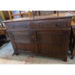 A 4' 20th Century oak side cabinet with two short drawers and pair of decorative panelled cupboard
