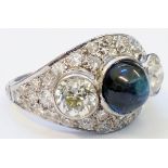 A marked "PLAT" ornate ring, set with central cabochon sapphire flanked by two large collar set