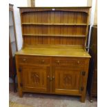 4' 3" 20th Century polished oak two part dresser with moulded two shelf open plate rack, over a base