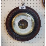 A 9" diameter carved walnut cased Holosteric wall barometer with printed dial and visible works to