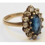 A 9ct. gold ring, set with blue stone in a white paste border