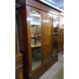 A 6' 2" Edwardian mahogany and strung triple wardrobe with moulded cornice, central panelled door