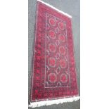 An early 20th Century Turkish Baluch wool gul main wedding rug, dark red, orange, white and black on