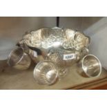 An Indian silver plated punch bowl of semi reeded design with embossed floral garlands and six