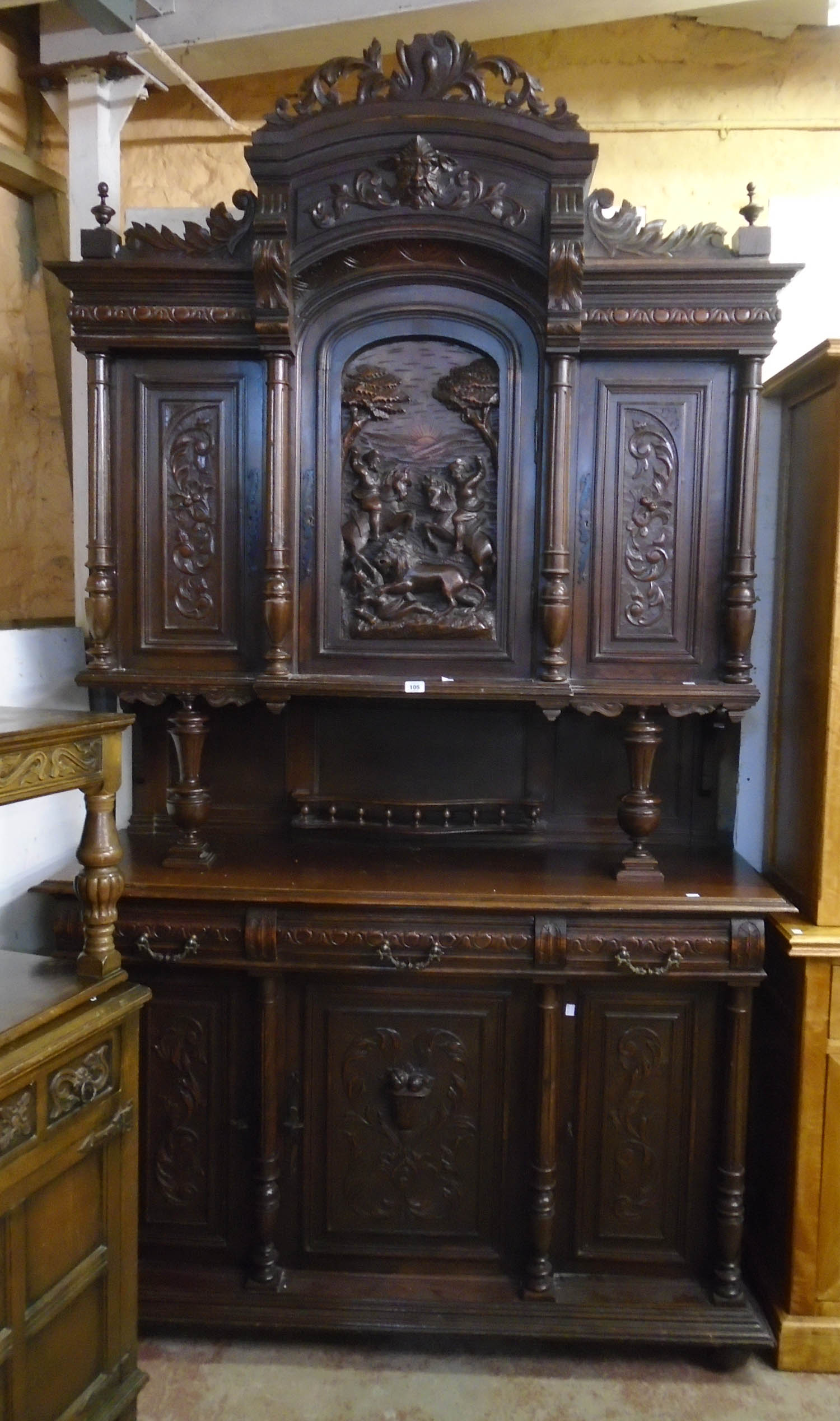 A 4' 11" 19th Century carved oak two part cabinet with Green Man mask to acanthus scroll pediment,