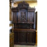 A 4' 11" 19th Century carved oak two part cabinet with Green Man mask to acanthus scroll pediment,