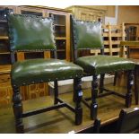 A set of four stained oak framed panel back dining chairs upholstered in studded green leather,