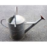 A vintage galvanised watering can with rose