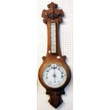 A Victorian carved oak framed aneroid banjo barometer/thermometer with printed ceramic dial and
