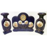 A ceramic clock garniture with printed Kaufmann style reserve panels on cobalt blue ground,