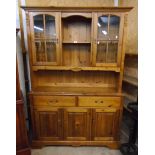 A 4' 3" modern waxed pine two part dresser with central open shelves and flanking glass panelled