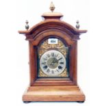 An early 20th Century German polished walnut cased table clock with decorative dial and Junghans