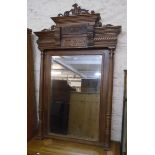 A 3' 5" late Victorian walnut framed mirror with ornate pierced and moulded pediment, bevelled plate