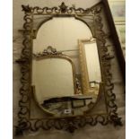 A 35" late Victorian brass framed bevelled wall mirror with open scroll and shell decorated border