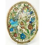 A 9 3/4" 18th Century Persian elliptical wall tile with bird and floral decoration