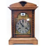 A German stained wood cased mantel clock with decorative arched dial and Junghans eight day gong