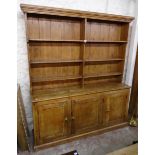 A 5' 9" waxed pine two part dresser with moulded cornice and partitioned three shelf open plate