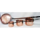 A set of three graduated copper saucepans and lids with iron handles - sold with a copper warming