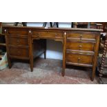 A 5' early 20th Century oak kneehole desk with brown rexine inset top, central drawer and six