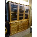 A 6' 11" "Malabar" book cabinet with moulded top and shelves enclosed by three glazed panel doors,