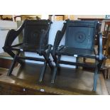 A pair of reproduction ebonised framed Glastonbury chairs with carved text and roundels - back