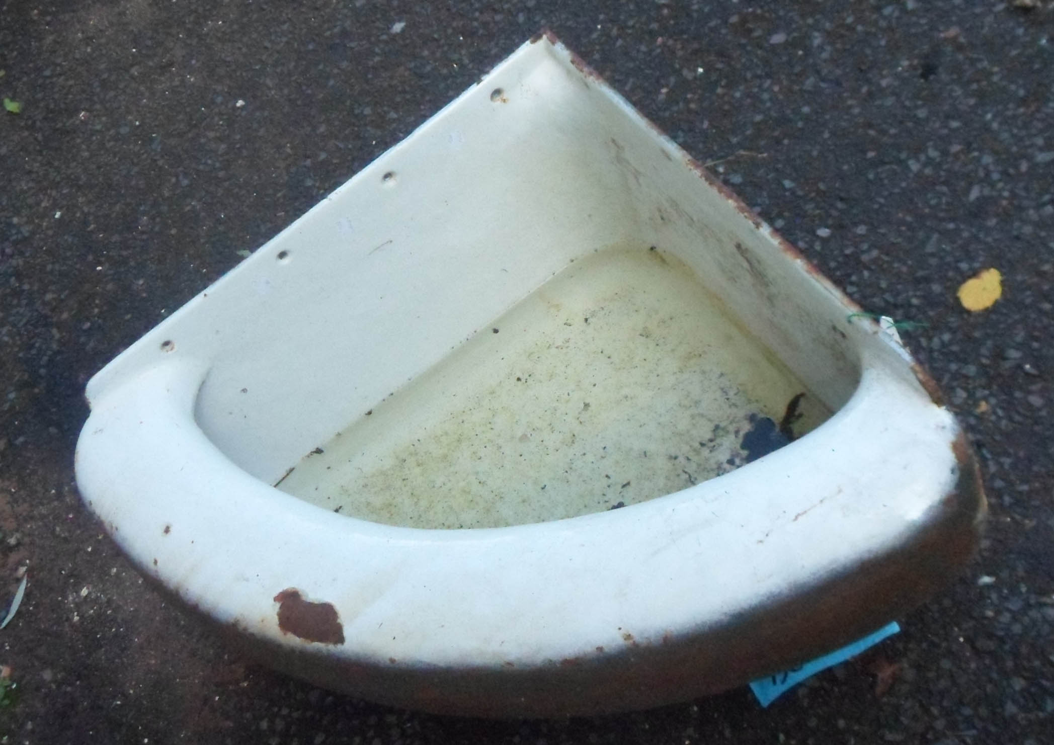 A cast iron enamelled corner drinking trough