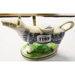 A 7 1/2" antique Staffordshire cow creamer with transfer print Willow pattern decoration, stood on a