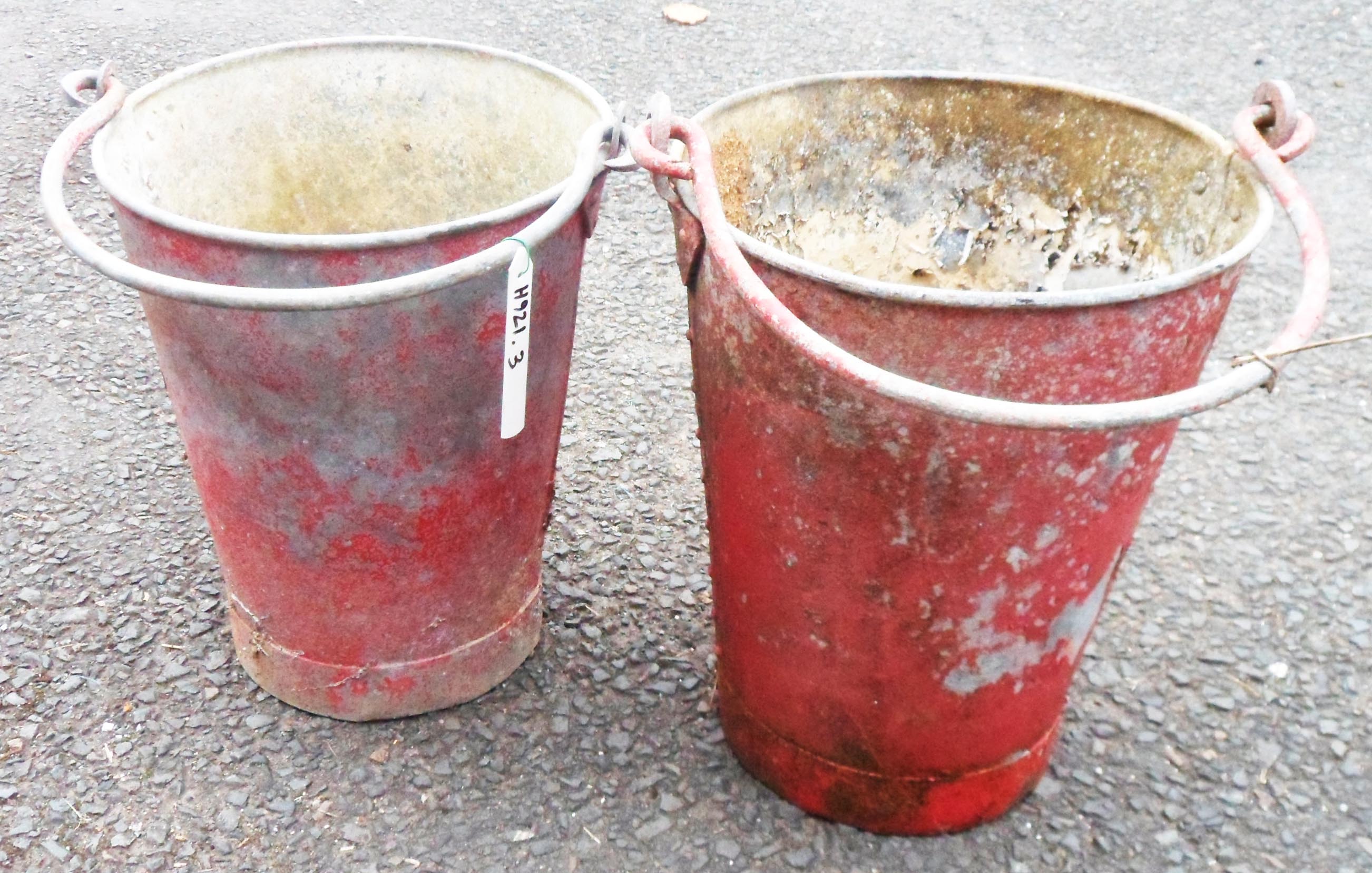 Two vintage fire buckets with remains of red painted finish