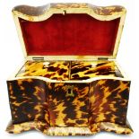 An early-mid 19th Century tortoiseshell clad serpentine front twin compartment tea caddy with red