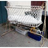 A vintage metal and rope mesh rocking crib