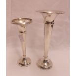 Two silver trumpet vases, one faceted, the other smooth, both with loaded bases