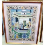 A gilt framed Mogul watercolour, depicting eighteen figures seated in a garden, with floral border -
