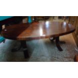 A 4' 2" rosewood veneered oval top coffee table, set on flanking triple splayed legs