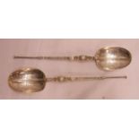 A pair of silver ornate cast long handled spoons with engraved bowls, dragon masks and twist