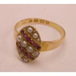 An 18ct. gold oval panel ring, set with slanting rows of seed pearls and tiny rubies