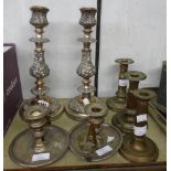 A pair of silver plated copper ornate candlesticks, three other candlesticks and two chamber