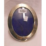 A silver fronted oval photograph frame with velvet easel back - to take 4" X 5 1/2"