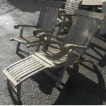 A pair of modern teak and metal mounted steamer deck chairs