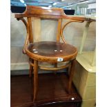 A late 19th Century stained bentwood framed elbow chair with pressed circular seat panel