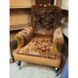 A late Victorian drawing room armchair with carpet bag style upholstery, turned front legs and later