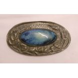 An oval Arts and Crafts pewter brooch with central Ruskin style cabochon