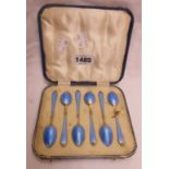 A cased set of six silver gilt teaspoons with engine turned enamelled handles and bowl backs -