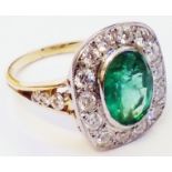A marked 18ct. yellow metal ring, set with central 2.42ct. emerald within a diamond encrusted border