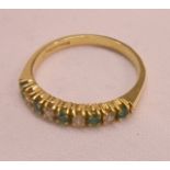 An 18ct. gold ring set with small diamonds interspersed with emeralds