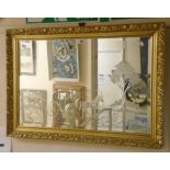 A modern gilt framed wall mirror with engraved horse and carriage decoration