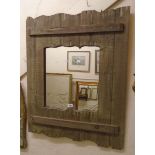 A rustic reclaimed timber framed wall mirror with shaped plate aperture