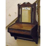 A small Edwardian walnut wall hanging mirror with lift-top trinket compartment, shelf and hooks